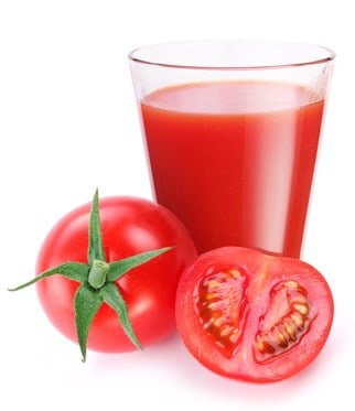 Ein Glas Tomatensaft mit frischen Tomaten.